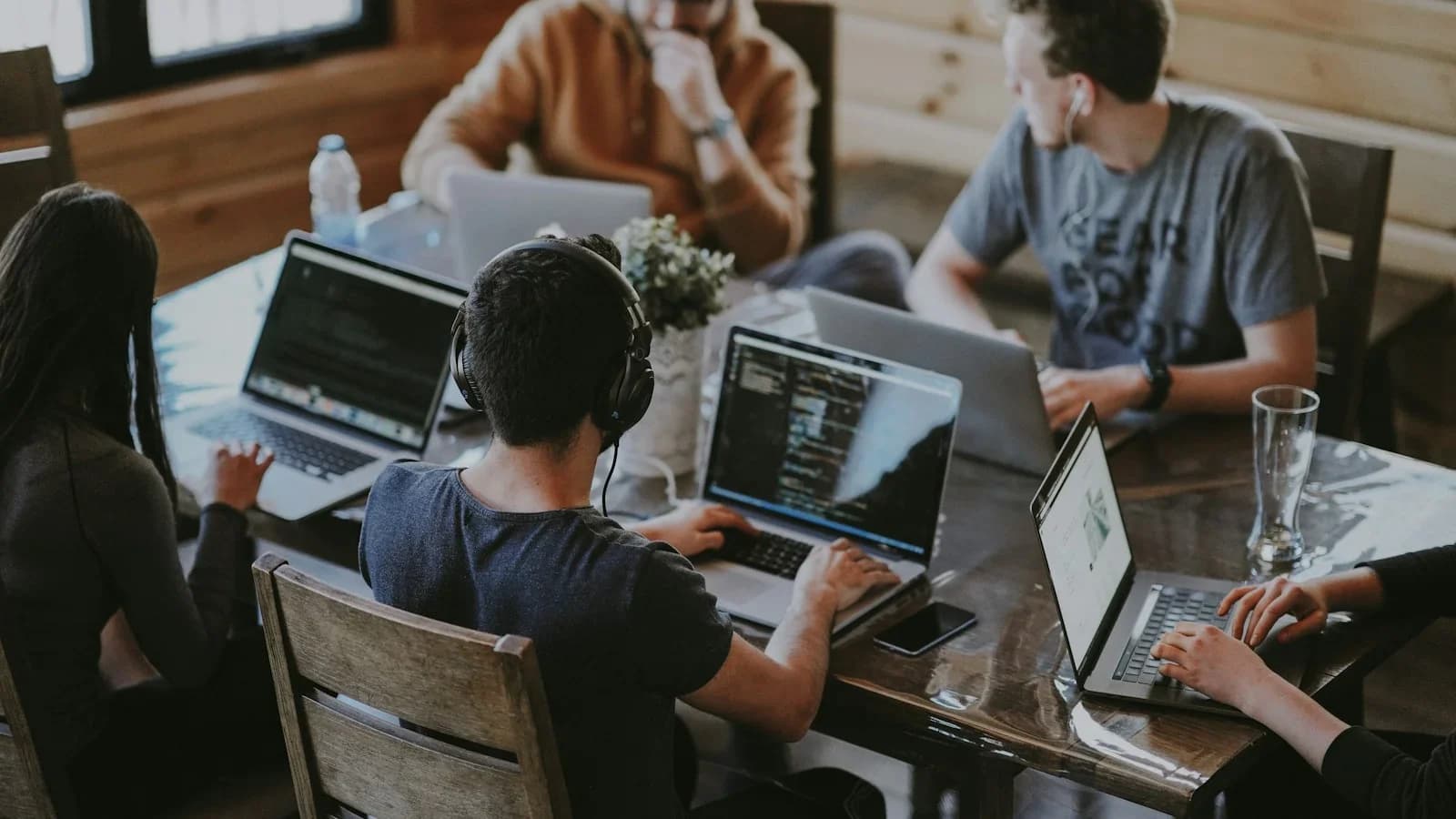 A team of software engineers collaborating on system architecture and code in a modern tech office